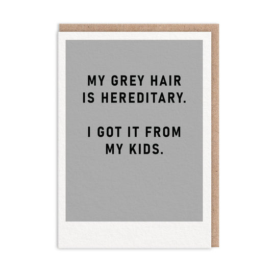 Grey greeting card with black foil text that reads "My Grey Hair Is Hereditary. I Got It From My Kids"
